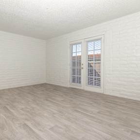 A room with a white door and a window with white blinds.