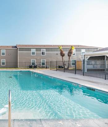 A swimming pool in front of apartment buildings.