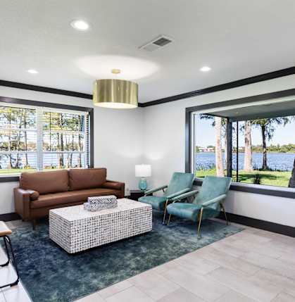 a living room with a couch and chairs and a large window