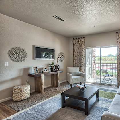 A living room with a white couch and a television on the wall.