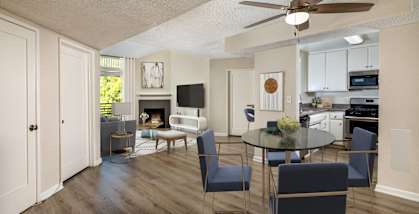 a living room and dining room with a table and chairs