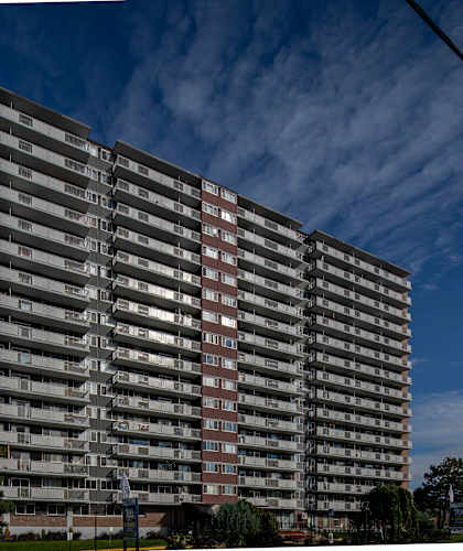 A tall residential building with many windows and balconies.