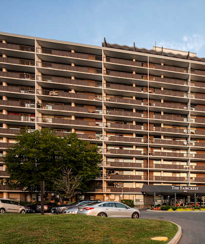 A large apartment complex with a parking lot in front.