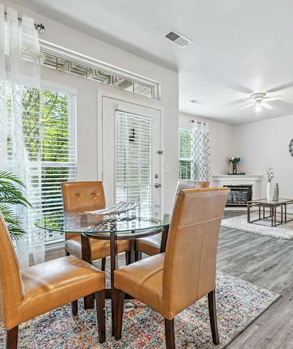A dining room with a glass table and chairs.