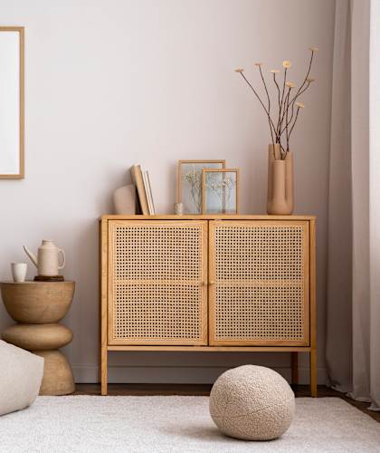 A room with a chair, a table, a cabinet, and a ball.