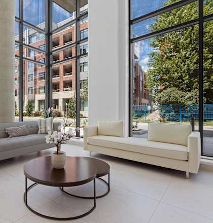A living room with a couch, coffee table, and large windows.