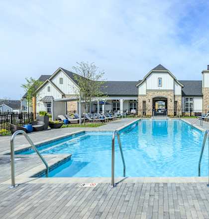 A large outdoor swimming pool with a building in the background.