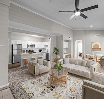 a living room with couches and chairs and a ceiling fan