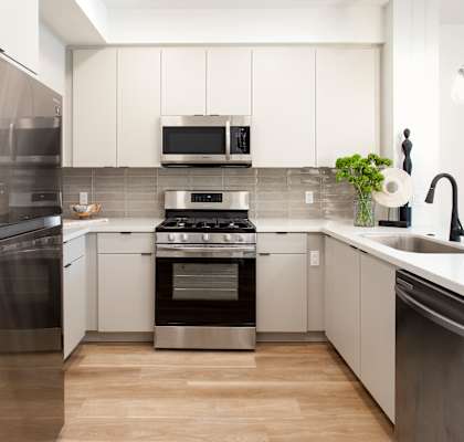 A modern kitchen with stainless steel appliances and white cabinetry. at The Reserve La Mirada, California, 90638