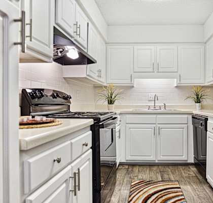 a kitchen with white cabinets and black appliances