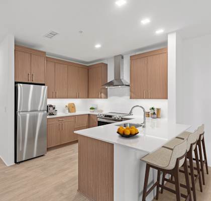 A modern kitchen with a white island and wooden cabinets.