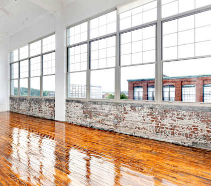 A large room with wooden floors and large windows.
