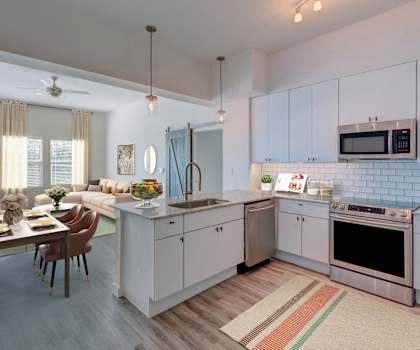 a kitchen and living room with white cabinets and a table and chairs