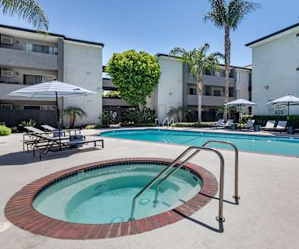 a swimming pool with a hot tub in front of a building