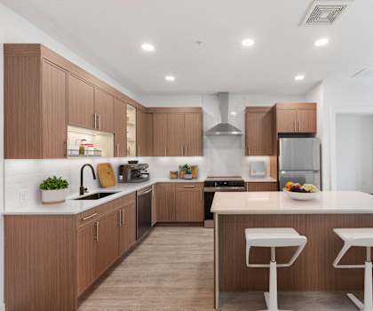 A modern kitchen with wooden cabinets and white countertops.