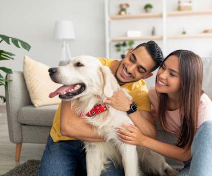 a man and woman sitting on a couch with a dog