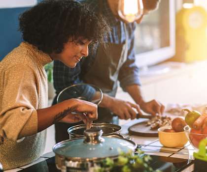 a couple cooking together in the kitchen