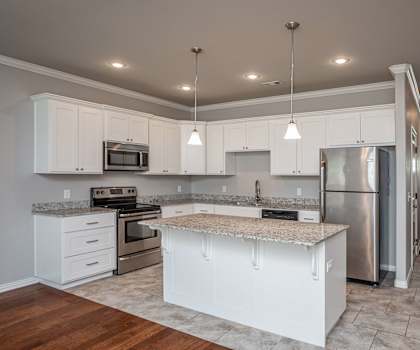 A kitchen with white cabinets and a granite countertop.
