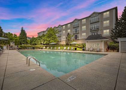 a swimming pool with an apartment building in the background