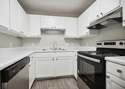 a kitchen with white cabinets and black appliances