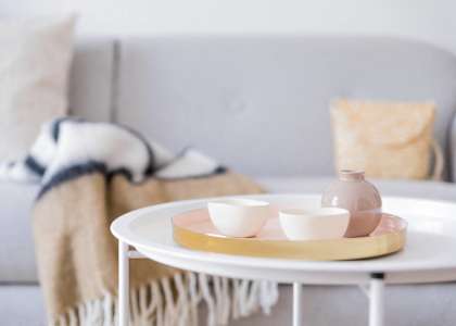 a tray with two cups and a vase on a table in a living room