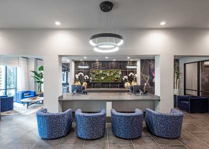 A modern waiting area with blue chairs and a reception desk.