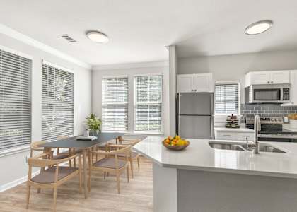 A modern kitchen with a dining table and chairs. at Sweetgrass Landing, Mount Pleasant, South Carolina