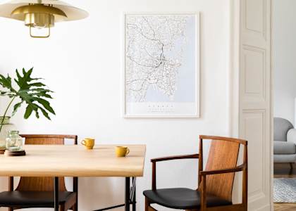 A dining room with a table, chairs, and a plant.