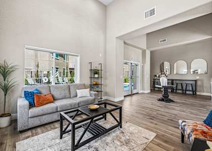 A living room with a grey couch and a black coffee table.