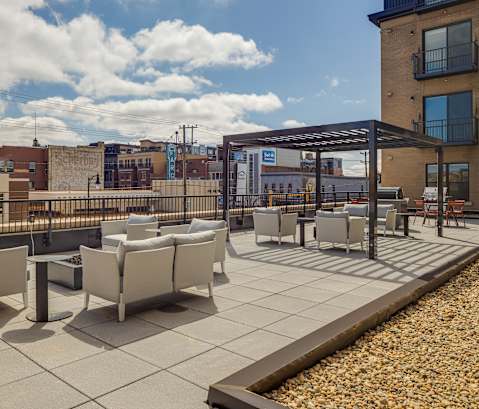 a rooftop patio with chairs and tables on a sunny day at Mercantile on Broadway, Fargo, ND 58102