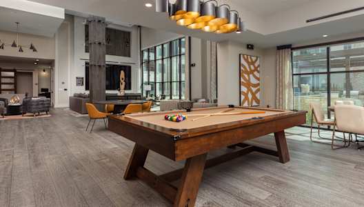 a pool table in the clubhouse at the bradley braddock road station apartments