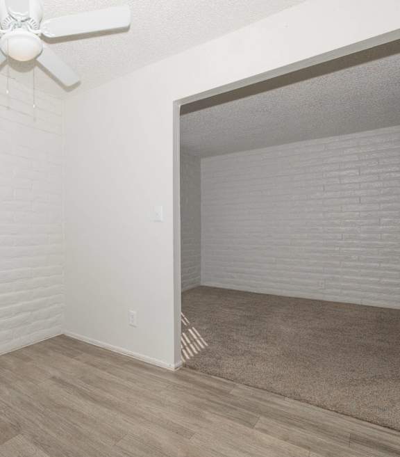 A room with a white ceiling fan and a window with blinds.