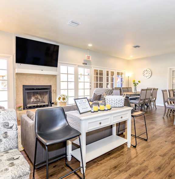 A living room with a fireplace and a television on the wall.