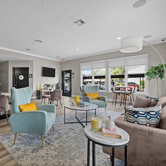 A modern living room with a grey couch, a blue armchair, and a coffee table.