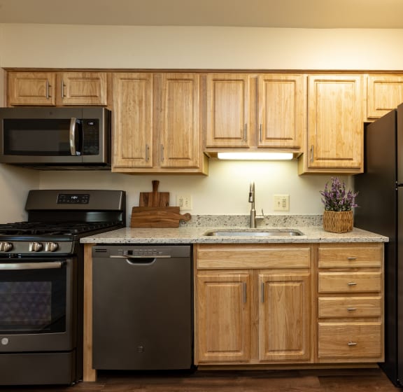a kitchen with wooden cabinets and stainless steel appliances