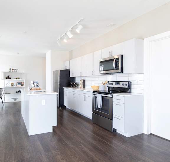 A modern kitchen with white cabinets and appliances.