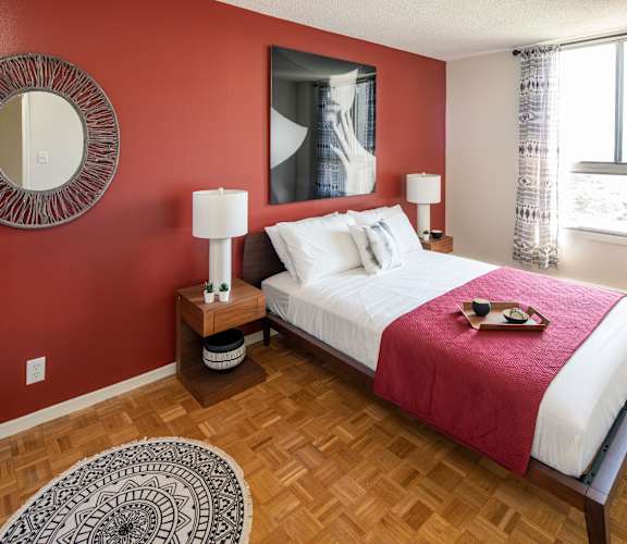A bedroom with a large bed and a red headboard.