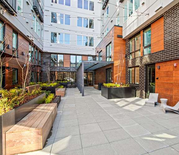a courtyard with benches and a brick building