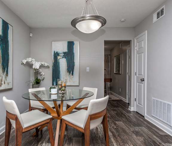 a dining room with a glass table and chairs