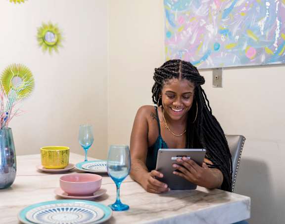 a woman sitting at a table with a tablet