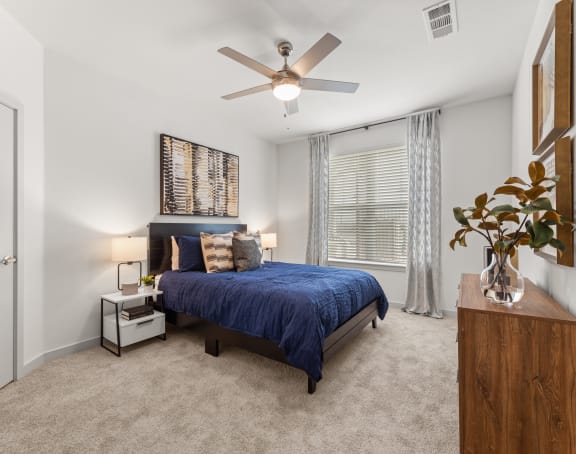 a bedroom with a bed and a ceiling fan