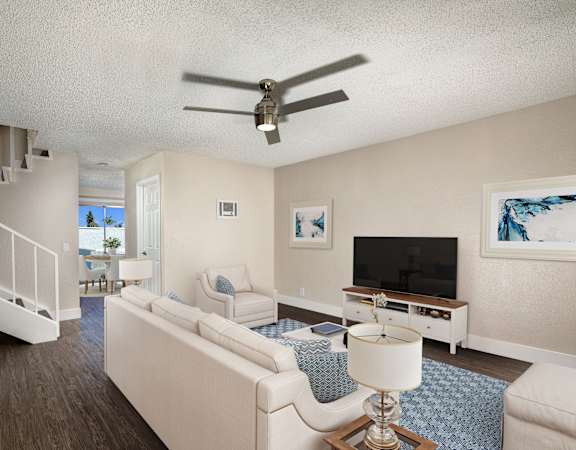 A living room with a white couch and a ceiling fan.