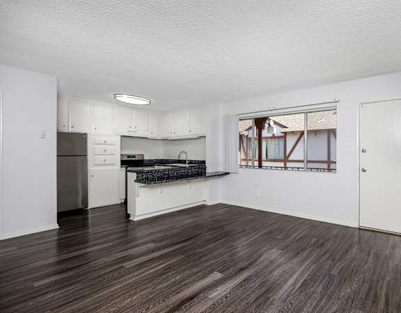 A kitchen with white cabinets and a black countertop.