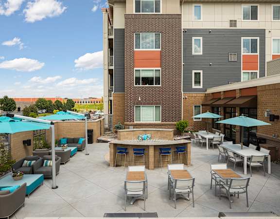 an outdoor patio with tables and chairs and umbrellas at Gabella at Parkside, Minnesota, 55124