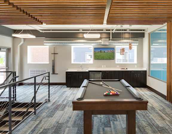 A room with a pool table and a view of the outside.
