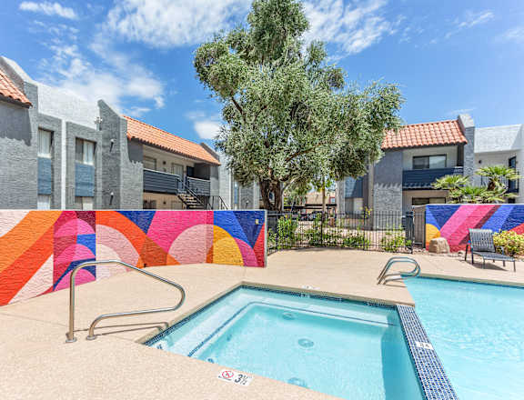 A swimming pool with a colorful mural on the wall.