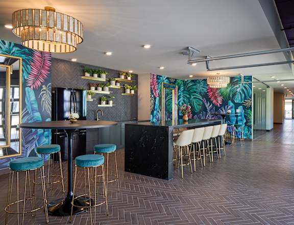 A bar area with a black counter and green bar stools.