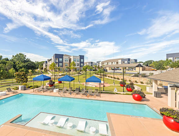 A pool with a slide and a building in the background.