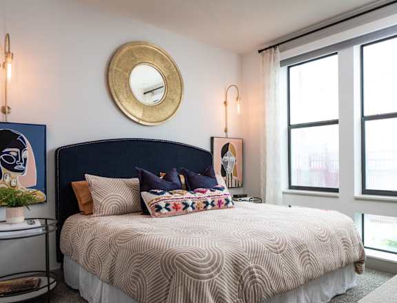 a bedroom with a large bed and a mirror on the wall