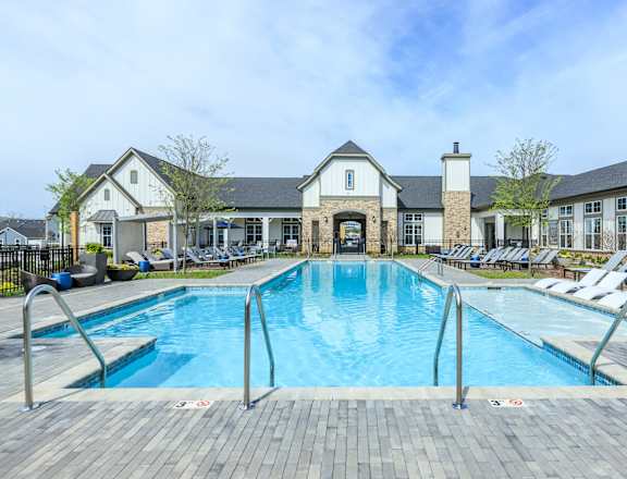 A large outdoor swimming pool with a building in the background.